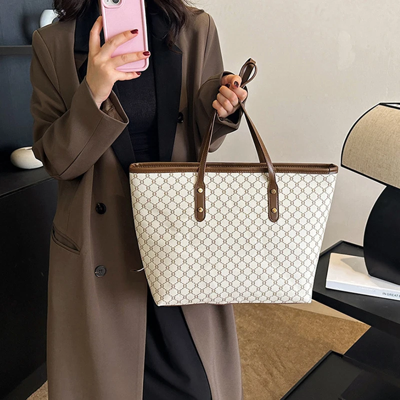 A model wearing a sleek minimalist pu leather tote bag carried over the shoulder in a city setting