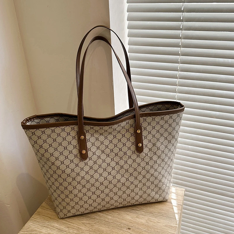 A model wearing a sleek minimalist pu leather tote bag carried over the shoulder in a city setting