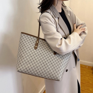 Model wearing a sleek minimalist pu leather tote bag carried over the shoulder in a city setting