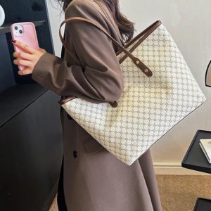Model wearing a sleek minimalist pu leather tote bag carried over the shoulder in a city setting