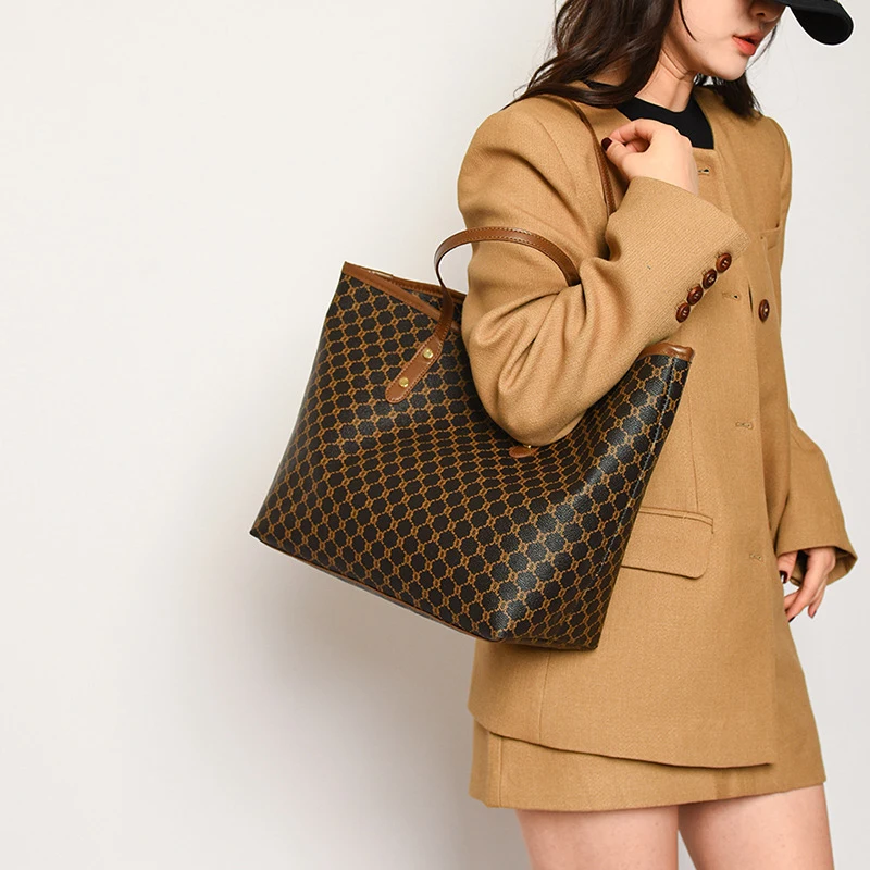 A model wearing a sleek minimalist pu leather tote bag carried over the shoulder in a city setting