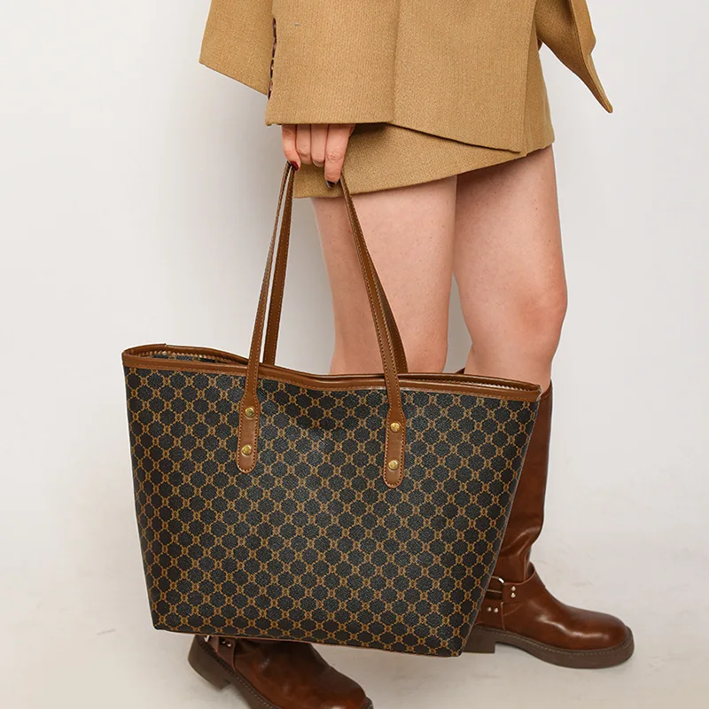 A model wearing a sleek minimalist pu leather tote bag carried over the shoulder in a city setting