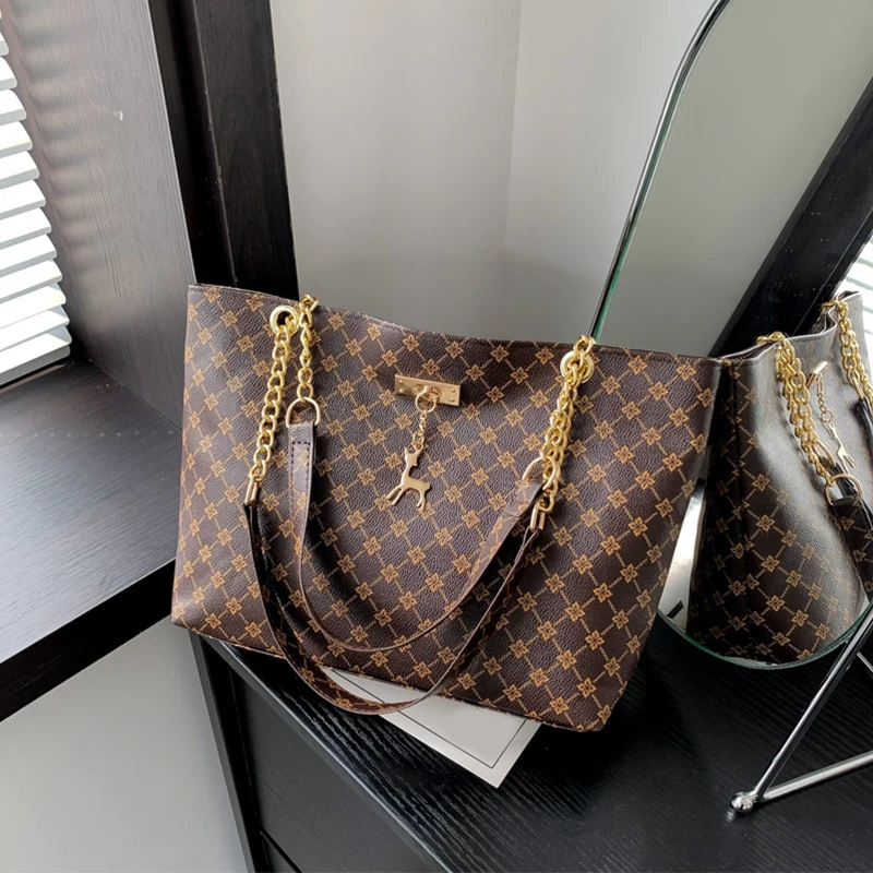 Monogram print soft leather tote bag with hanging charm accessory