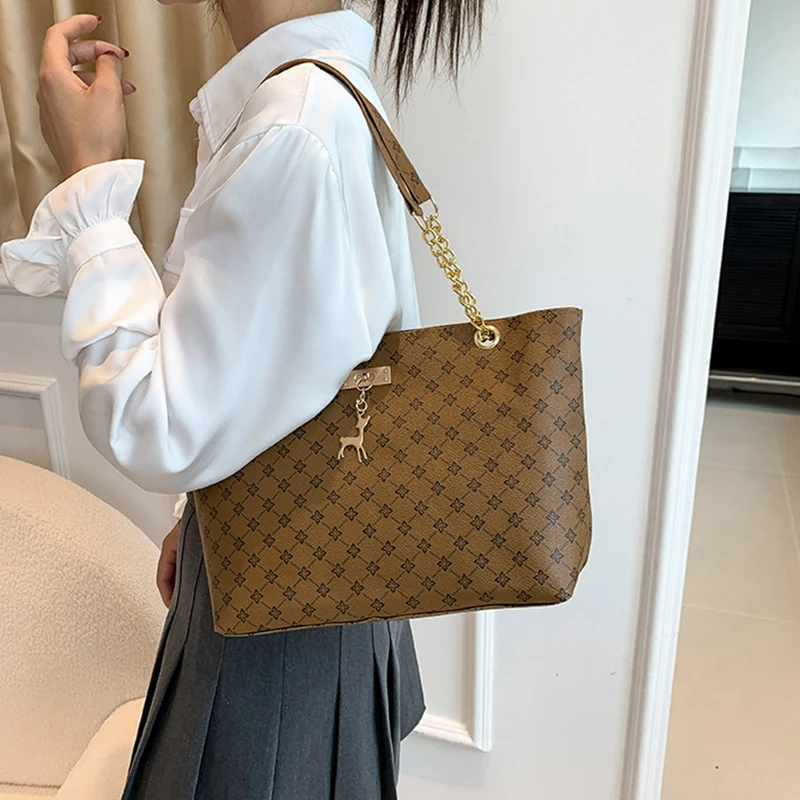 Monogram print soft leather tote bag with hanging charm accessory