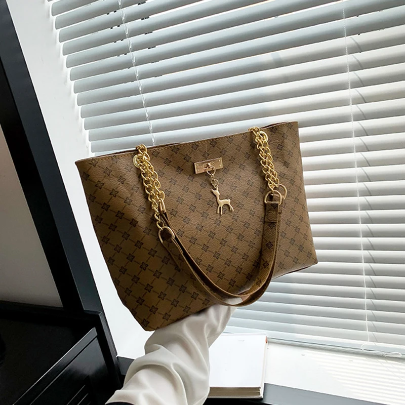 Monogram print soft leather tote bag with hanging charm accessory