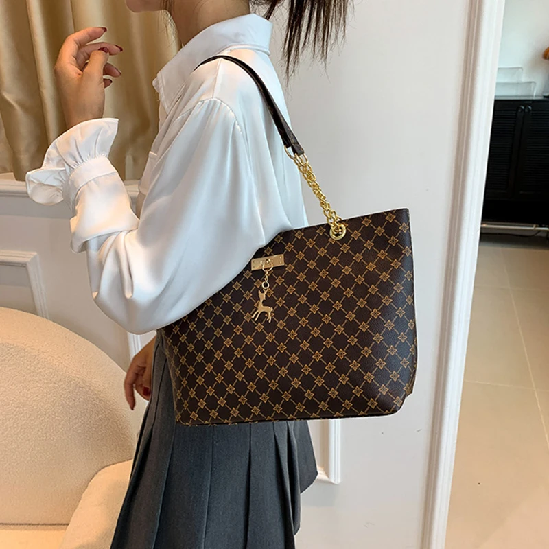 Monogram print soft leather tote bag with hanging charm accessory