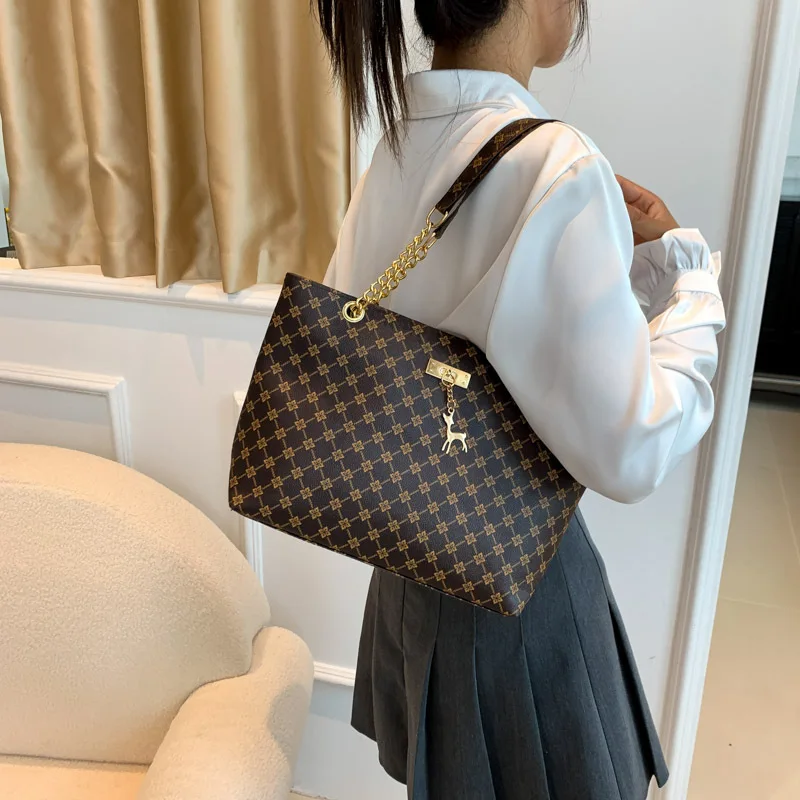 Monogram print soft leather tote bag with hanging charm accessory