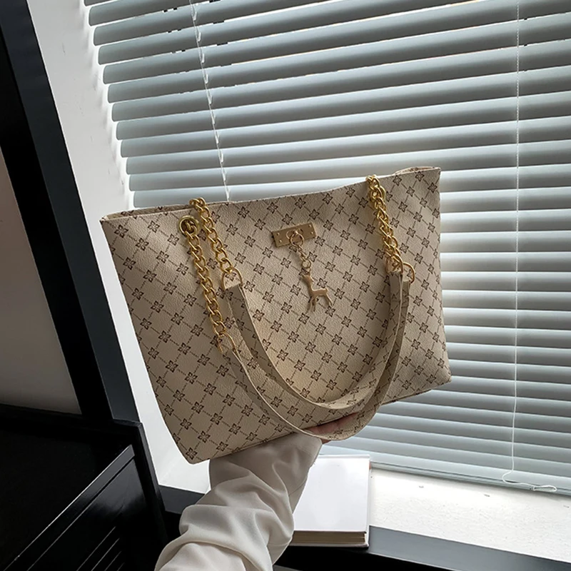 Monogram print soft leather tote bag with hanging charm accessory