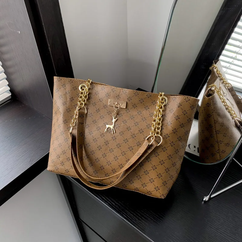 Monogram print soft leather tote bag with hanging charm accessory