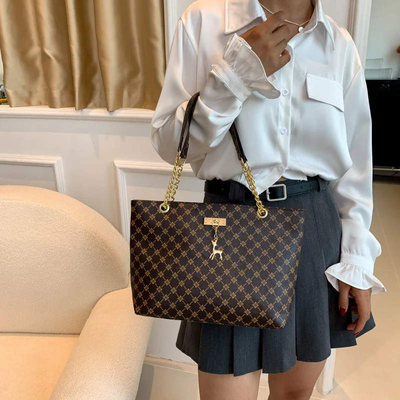 Monogram print soft leather tote bag with hanging charm accessory