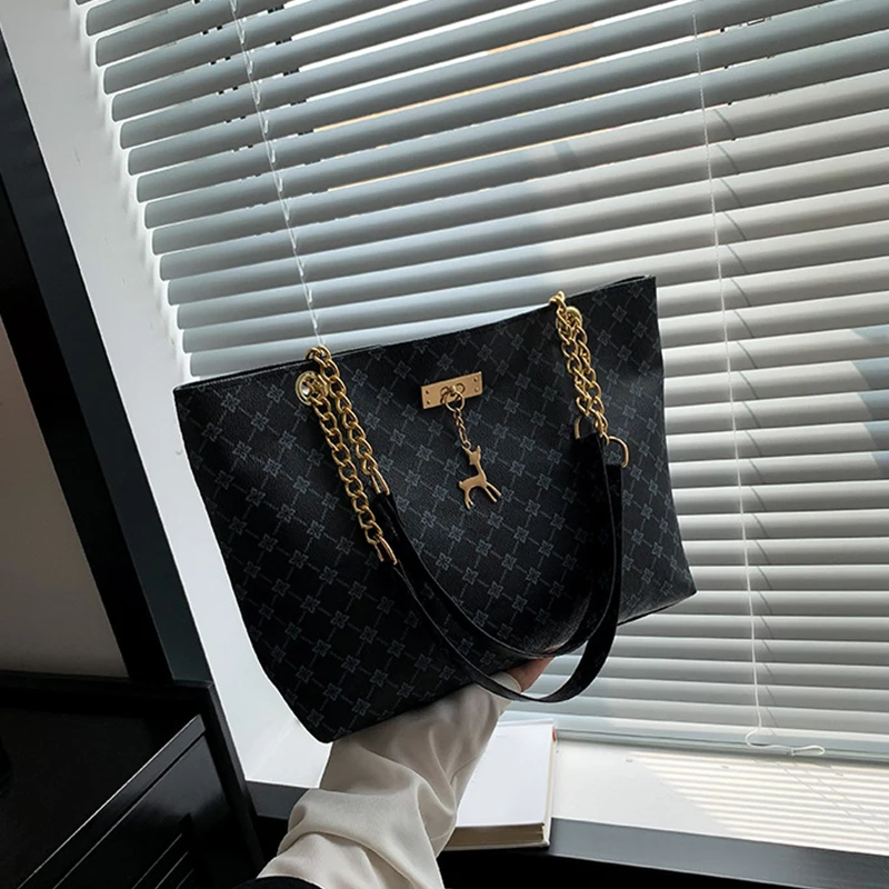 Monogram print soft leather tote bag with hanging charm accessory