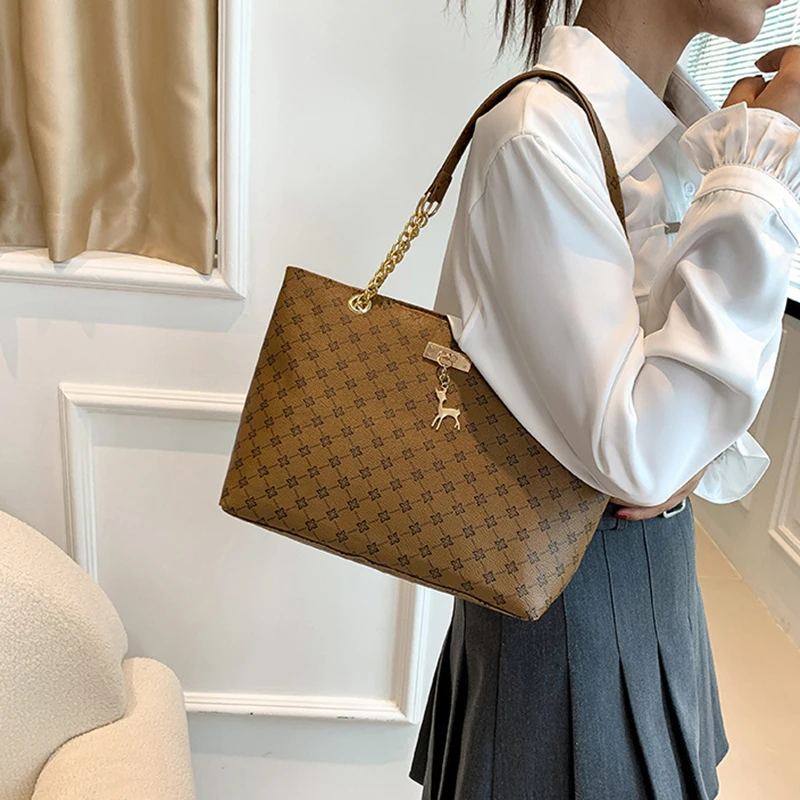 Monogram print soft leather tote bag with hanging charm accessory